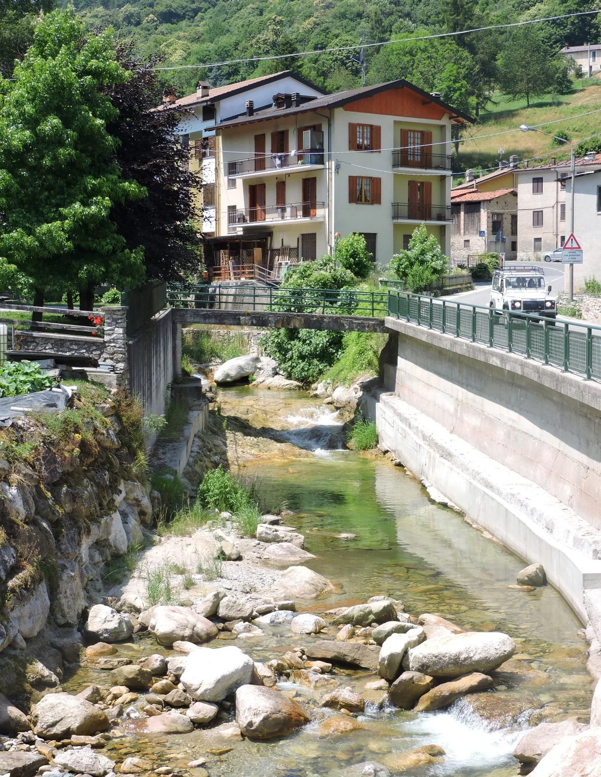 Il torrente Maudagna che scorre tra le case di Frabosa Sottana, con i boschi della valle sullo sfondo